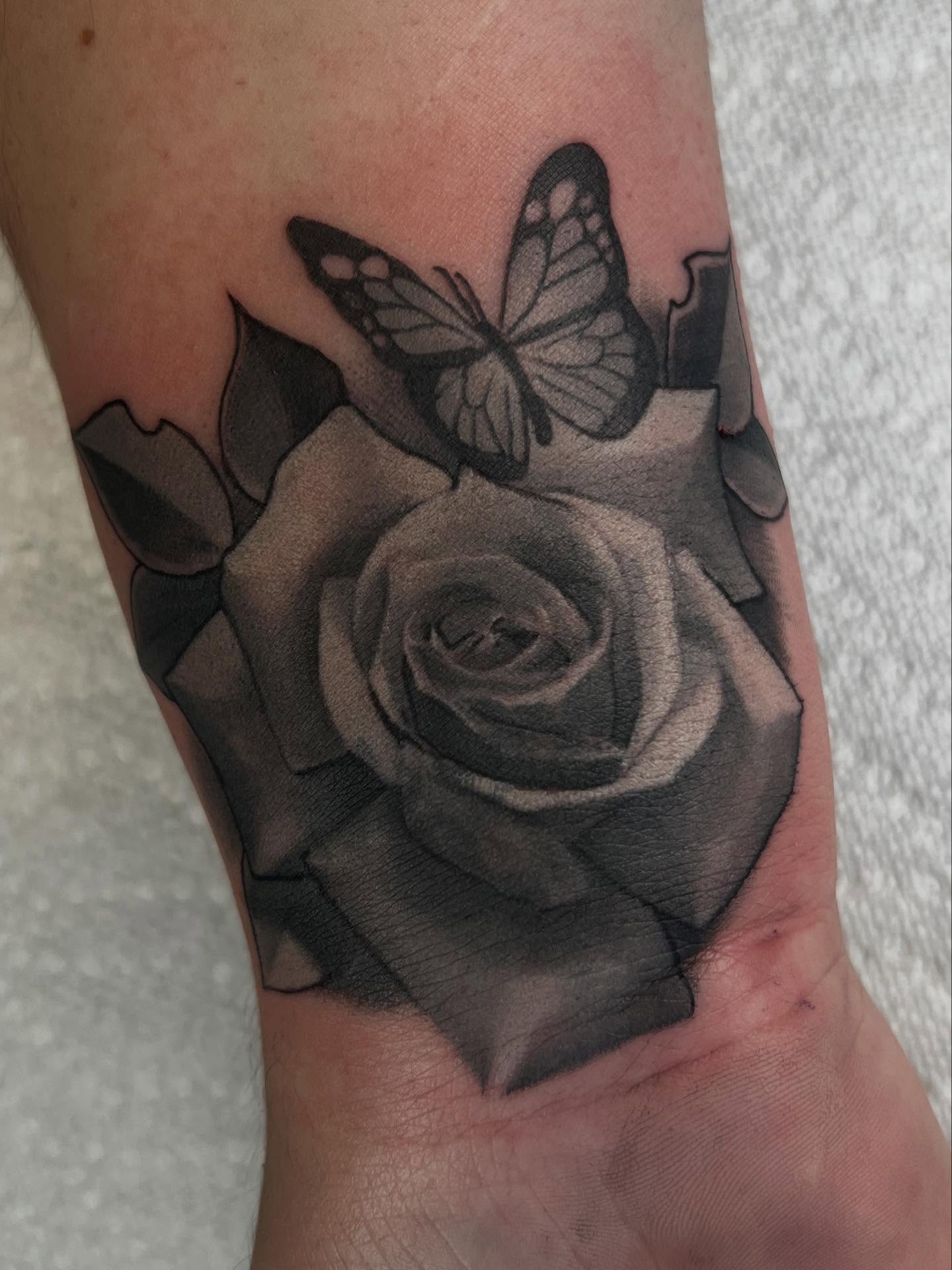 Black and grey realism rose and butterfly tattoo by Juan Palomares